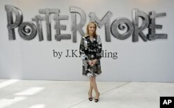 FILE - British author J.K. Rowling poses for photographers as she announces her new website project Pottermore at the Victoria and Albert Museum in London, June 23, 2011