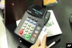 FILE - A credit card is used to pay a bill.