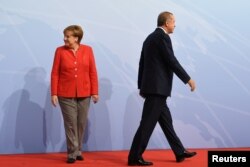 German Chancellor Angela Merkel and Turkey President Recep Tayyip Erdogan go their separate ways after a handshake greeting at the beginning of the G20 summit in Hamburg, Germany, July 7, 2017.