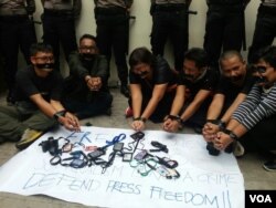 Sepuluh wartawan Indonesia berdemonstrasi dengan mengikat tangan dan meletakkan kartu tanda pengenal wartawan, memprotes vonis terhadap dua wartawan Reuters di Myanmar. Foto: VOA/Fathiyah