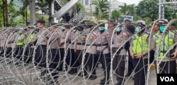 Kawat besi yang dijaga polisi di kawasan Patung Kuda, Jakarta yang membatasi jalan ke Istana Merdeka. (Foto: VOA/Sasmito Madrim)
