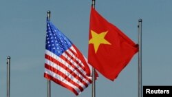 FILE - The U.S. flag flutters next to the Vietnamese flag during a welcoming ceremony for the U.S. defense secretary in Hanoi, Vietnam June 1, 2015. Vietnam has advocated for relaxation of the arms embargo to reflect a greater level of trust with the U.S.