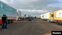 Trucks carrying humanitarian aid wait for the reopening of the Rafah crossing on the Egyptian side so they can enter Gaza amid the ongoing conflict between Israel and Hamas, in Rafah, Egypt, on Oct. 17, 2023.