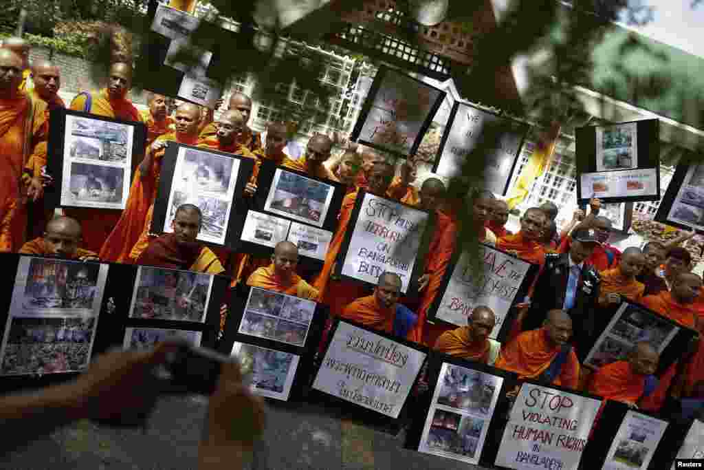 Buddhist monks hold banners and photographs as they protest in front of the U.N. office in Bangkok, Thailand, October 3, 2012. 