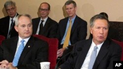 Ohio Gov. John Kasich, front right, and Ohio Senate President Keith Faber, front left, both Republicans, discuss the state budget, June 26, 2015, at the Statehouse in Columbus, Ohio. Ohio is resuming executions using a three-drug combination.
