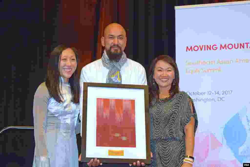 លោក Many Uch (កណ្តាល) ពលរដ្ឋ​អាមេរិកាំង​ដើម​កំណើត​ខ្មែរ​ឡើង​ទទួល​ពានរង្វាន់​បុគ្គល​ផ្លាស់ប្ដូរ​សង្គម​ពី​អ្នក​តំណាង​អង្គការ SEARAC នៅ​សណ្ឋាគារ Renaissance ក្នុង​រដ្ឋធានី វ៉ាស៊ីនតោន កាល​ពី​ថ្ងៃ​ទី​១៣ ខែ​តុលា ឆ្នាំ​២០១៧។ (ហុង ចិន្តា/VOA)