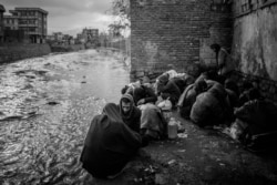 Drug users at a riverbank in Kabul. (Maciej Stanik/VOA)
