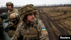 Ukrainian soldiers with the 43rd Heavy Artillery Brigade sit atop 2S7 Pion self propelled cannon on the battlefield, as Russia's attack on Ukraine continues, during intense shelling on the front line in Bakhmut, Ukraine, Dec. 26, 2022. 