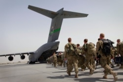 FILE - US soldiers load onto a US military plane as they leave Afghanistan, at the US base in Bagram, north of Kabul, Afghanistan, July 14, 2011.