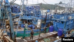 រូបឯកសារ៖ មន្ត្រីប៉ូលិសឈរពិនិត្យទូកនេសាទសមុទ្រដែលឈប់ចតនៅកំពង់ផែ Songkhla ភាគខាងត្បូងប្រទេសថៃ កាលពីថ្ងៃទី២៣ ខែធ្នូ ឆ្នាំ២០១៥។