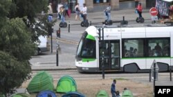 Ilustrasi - Sebuah trem melewati kamp tenda migran di taman umum di pusat kota Nantes, Prancis barat, 30 Agustus 2018. (AFP / LOIC VENANCE)
