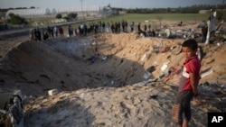 រូបឯកសារ៖ កុមារជនជាតិប៉ាឡេស្ទីនម្នាក់មើលទៅរណ្តៅមួយពីការវាយប្រហារដោយមីស៊ីលអ៊ីស្រាអែល ដែលបានបំផ្លាញផ្ទះមួយខ្នង និងសម្លាប់សមាជិកប្រាំបួននាក់នៃគ្រួសារមួយ នៅតំបន់ Gaza កាលពីថ្ងៃទី១៤ ខែវិច្ឆិកា ឆ្នាំ២០១៩។ 