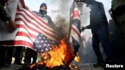 ក្រុម​បាតុករ​ដុត​ទង់​ជាតិ​សហរដ្ឋ​អាមេរិក និង​ទង់​ជាតិ​អង់គ្លេស ក្នុង​ពេល​ធ្វើ​បាតុកម្ម​ប្រតិកម្ម​ទៅ​នឹង​ការ​សម្លាប់​ឧត្តម​សេនីយ៍ Soleimani មេបញ្ជាការ​កង​កម្លាំង​ពិសេស​ Quds​ របស់​អ៊ីរ៉ង់ កាល​ពី​ថ្ងៃ​ទី​៣ មករា ២០២០។