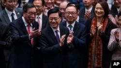 资料照片: 2024年3月19日香港立法会通过《基本法》第 23 条立法后，香港行政长官李家超鼓掌。