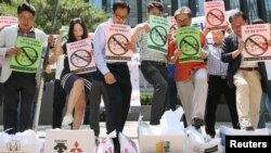 South Korean merchants step on boxes bearing logos of Japanese products during a rally to declare a boycott of Japanese goods in Seoul, South Korea, July 5, 2019. 