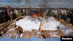 រូបឯកសារ៖ មន្ត្រី​ប៉ូលិស​និង​ពលរដ្ឋ​នៅ​ឯ​ពិធី​ដុត​បំផ្លាញ​​គ្រឿង​ញៀន​ដែល​ត្រូវ​​ចាប់​បាន​ នៅ​ឯ​ពិធី​មួយ​នៅរាជធានី​ភ្នំពេញ​កាល​ពី​ថ្ងៃ​ទី​២៨ ខែ​សីហា ឆ្នាំ​២០១២។ ​