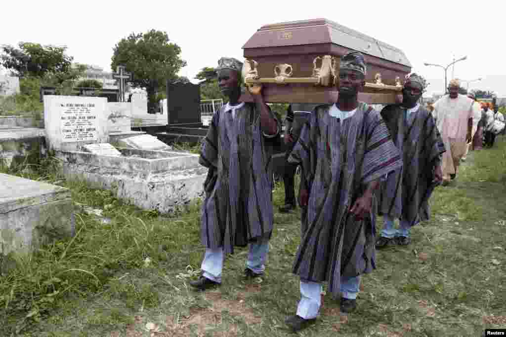 Pallbearers carry a coffin through a cemetery during a funeral ceremony in Lagos, Nigeria, May 31, 2013. 