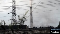 FILE - Smoke rises from a chimney in downtown Pyongyang, North Korea Sept. 11, 2018.