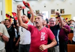 Supporters of Nicaraguan President Daniel Ortega shout slogans against anti-government people during the funeral mass for Nicaraguan poet and priest Ernesto Cardenal at the Metropolitan Cathedral in Managua, Nicaragua, March 3, 2020.