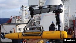 Crew aboard the Australian Defence Vessel Ocean Shield move the U.S. Navy's Bluefin-21 autonomous underwater vehicle into position for deployment in the southern Indian Ocean to look for the missing Malaysia Airlines flight MH370, April 14, 2014.