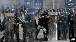 Police prepare to fire on protestors at the Hong Kong Polytechnic University in Hong Kong, Sunday, Nov. 17, 2019. (AP Photo/Achmad Ibrahim)