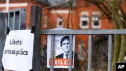 FILE - A picture of Carlos Puidgemont is fixed in front of the entrance building of a prison in Neumuenster, northern Germany, March 27, 2018. Puigdemont, the fugitive ex-leader of Catalonia and ardent separatist, was arrested by German police as he tried to enter the country from Denmark. 