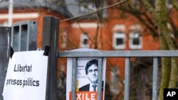 Gambar Carles Puidgemont ditempel di gerbang masuk penjara di Neumuenster, utara Jerman, Selasa, 27 Maret 2018. Carles Puigdemont, mantan pemimpin Catalonia yang sedang dalam pelarian, diyakini ditahan di penjara ini. Puidgemont ditangkap polisi Jerman saat berusaha memasuki negara ini dari Denmark. (Frank Molter/dpa via AP)