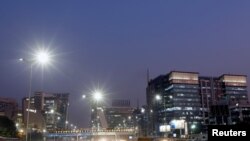 Vehicles drive past the commercial towers in Gurugram on the outskirts of New Delhi, India, Nov. 23, 2017. 