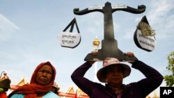 រូបឯកសារ៖ ពលរដ្ឋដែលរងគ្រោះពីបញ្ហាជម្លោះដីធ្លីនៅតំបន់បឹងកក់ កាន់បដាជញ្ជីងយុត្តិធម៌ ខណៈពេលចូលរួមបាតុកម្មនៅមុខក្រសួងយុត្តិធ៌ រាជធានីភ្នំពេញ កាលពីថ្ងៃទី៦ ខែឧសភា ឆ្នាំ២០១៣។