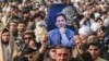 Seorang pendukung mantan PM Imran Khan yang dipenjara, memegang posternya selama pertemuan partai Pakistan Tehreek-e-Insaf (PTI) untuk memperingati "Hari Martir" guna menghormati mereka yang diduga tewas selama aksi protes bulan lalu, di Peshawar 15 Desember 2024. 