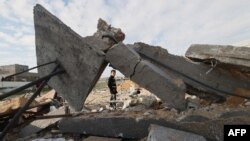 Дете поминува покрај уништената куќа во Рафа на 18 февруари 2024 година, по израелските воздушни напади во текот на ноќта врз јужниот пограничен град на појасот Газа. во услови на тековни битки меѓу Израел и Хамас