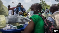 Seorang petugas kesehatan sedang menyuntikkan vaksin Ebola untuk seorang warga di Gueckedou, Guinea, 23 Februari 2021. 