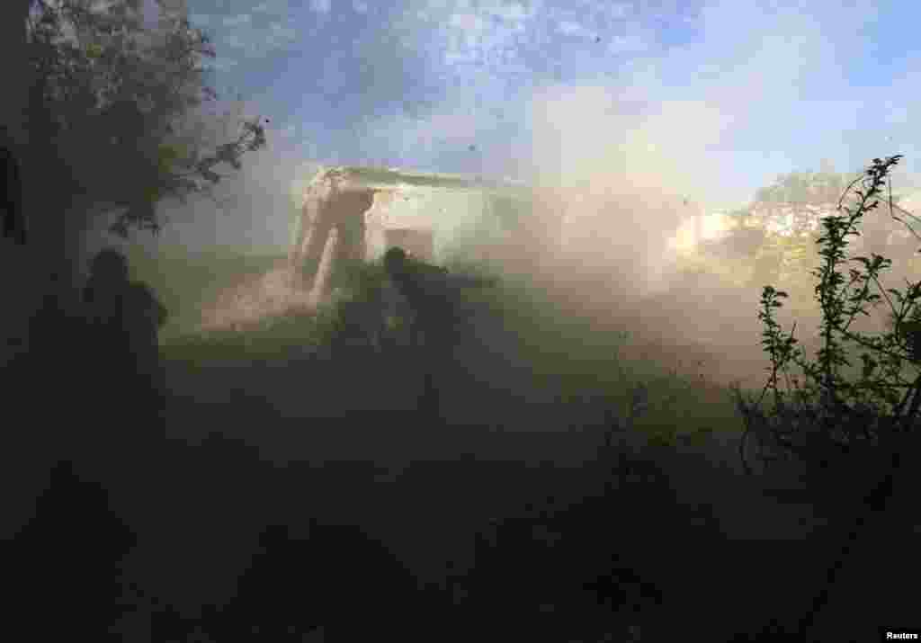 A rebel fighter runs for cover after firing towards the regime&#39;s post where forces loyal to Syria&#39;s President Bashar al-Assad are located, in Idlib countryside, April 7, 2014.