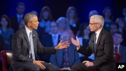 President Barack Obama, left, speaks during a CNN televised town-hall meeting hosted by Anderson Cooper, right, at George Mason University in Fairfax, Va., Jan. 7, 2016.