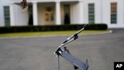 An unused microphone stand sits outside the West Wing at the White House, Tuesday, Jan. 19, 2021, in Washington. On President Donald Trump's last full day in office, there was an eerie quiet, with no public events scheduled, his last event being Jan…