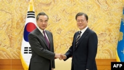 Presiden Korea Selatan Moon Jae-in bertemu dengan Menteri Luar Negeri China Wang Yi yang sedang berkunjung di Seoul, 26 November 2020. (Foto: The Blue House / AFP)