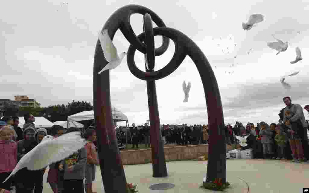People watch 88 white peace doves being released at Dolphin Point in Coogee in Sydney, Australia, October 12, 2012 during the 10th anniversary memorial service for the 2002 Bali Bombings.