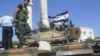 Members of the Free Syrian Army stand atop a tank in Azzaz, Aleppo province July 19, 2012. 