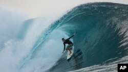FILE - A surfer rides a wave in Teahupo'o, Tahiti, French Polynesia, Saturday, Jan. 13, 2024. The world-famous surf spot is set to host the 2024 Paris Olympics surfing competition. 