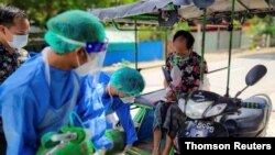 Volunteers help a coronavirus disease (COVID-19) patient with extra oxygen in the town of Kale, Sagaing Region, Myanmar, July, 2021.