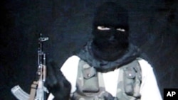 Un homme masqué assis à côté d'un pistolet automatique lisant une déclaration d'Abdul Rehman al-Ansari, le chef d'al-Qaïda Fil Hind à Srinagar, la principale ville de l'État indien du Jammu-et-Cachemire, le 8 juin 2007.