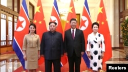 Pemimpin Korea Utara Kim Jong Un dan istrinya Ri Sol Ju berfoto bersama dengan Presiden China, Xi Jinping dan istri Peng Liyuan di Balai Besar Rakyat di Beijing, China, 28 Maret 2018.(Foto: Ju Peng/Xinhua via REUTERS).