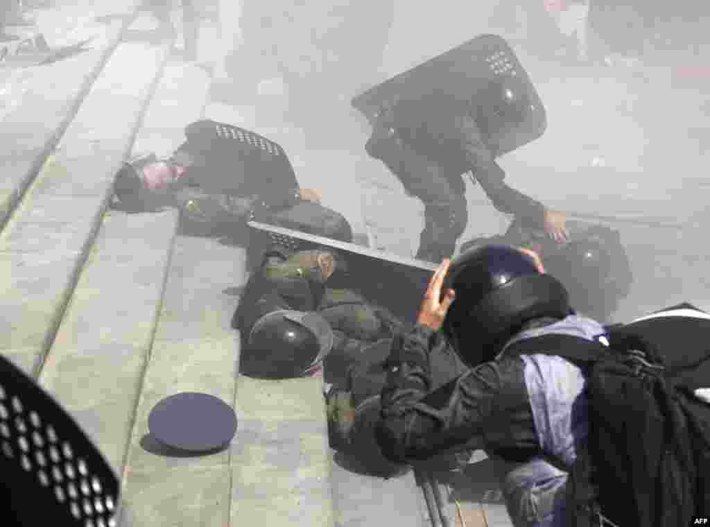Police officers help wounded colleagues during clashes with activists of few radical Ukrainian parties in front of the parliament in Kyiv, Aug. 31, 2015.