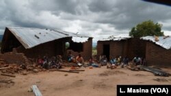 Victims of mob attacks sitting outisde their demolished houses on suspicion that they are withholding rains.