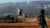 An Israeli soldier stands guard next to an Iron Dome rocket interceptor battery deployed near the northern Israeli city of Haifa, January 28, 2013. 