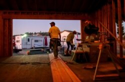In this Monday, Nov. 4, 2019, photo, Bobbie Chandler, left, and his wife, Jenna, stand in the home they are building in Santa Rosa, Calif.