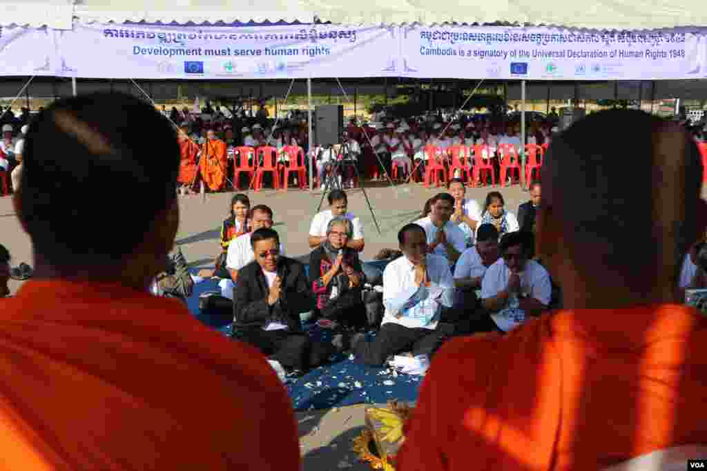 ព្រះ​សង្ឃ​កំពុង​សូត្រ​ប្រោះ​ព្រំ​ដល់​អ្នក​ចូលរួម​ដែល​ជា​ពលរដ្ឋ កម្មករ និង​តំណាង​អង្គការ​សង្គម​ស៊ីវិល​ ក្នុង​ពិធីប្រារព្ធ​ទិវា​សិទ្ធិ​មនុស្ស​អន្តរជាតិ​លើកទី​៧១ នៅ​សួន​ប្រជាធិបតេយ្យ នា​ថ្ងៃ​ទី​១០ ខែ​ធ្នូ ឆ្នាំ​២០១៩។ (កាន់ វិច្ឆិកា/VOA)