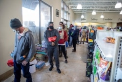 Customers, whose homes are without electric power, wait in line to purchase food and snacks at a gas station in Pflugerville, Texas, Feb. 16, 2021. (Ricardo B. Brazziell/via Reuters)