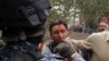 Iraqi officer, left, hits, detains journalist Mohammed al-Rased, center, during a demonstration in Basra, March 4, 2011.