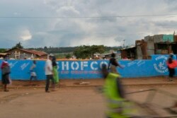 People walk across a bridge with a message written on the barriers advocating personal efforts to stem the spread of the COVID-19 coronavirus in the Kibera slum, Nairobi, on April 14, 2020.